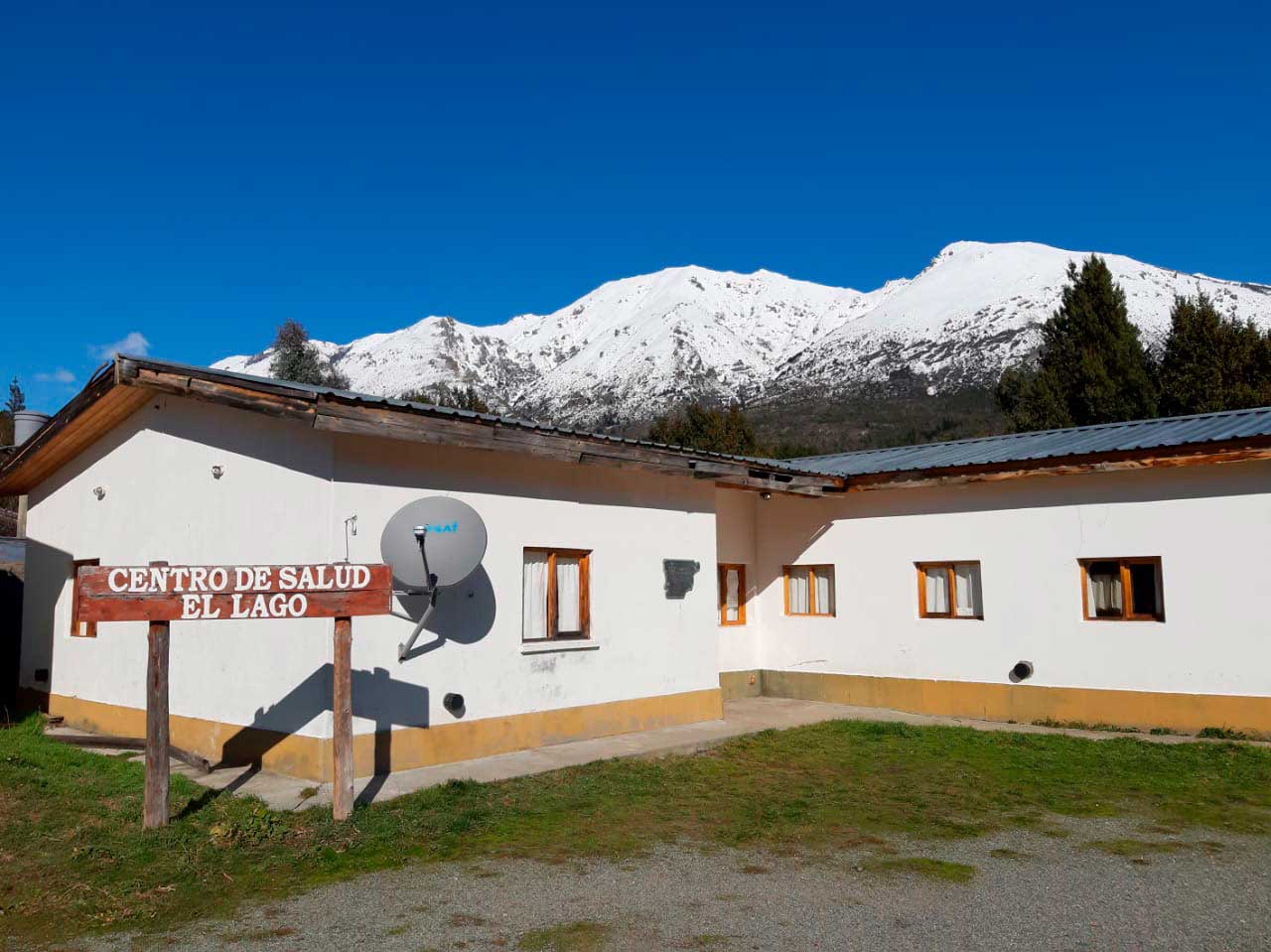 Una antena de internet instalada en el Centro de Salud de Lago Puelo, con la cordillera nevada detrás.